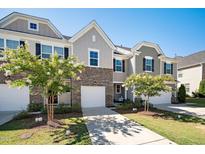 Charming townhome featuring stone accents, a driveway and well-manicured lawn at 835 New Derby Ln, Apex, NC 27523