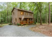 Charming home nestled amongst mature trees with a cozy front porch and gravel driveway at 1012 King Cir, Chapel Hill, NC 27516