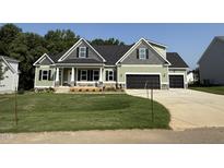 Charming home with a black roof, three-car garage, and well-maintained lawn in a suburban neighborhood at 111 Hot Springs Way, Benson, NC 27504