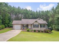 Charming single-story home with manicured lawn, attached garage, and welcoming front porch at 1210 Bayview Ct, Franklinton, NC 27525
