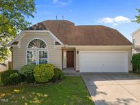 Charming single-Gathering home with well-maintained landscaping, attached garage, and welcoming front entrance at 1308 Snyder St, Durham, NC 27713