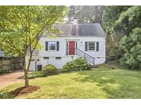 Charming home boasts a well-manicured lawn, bright red door, and attached garage at 1516 Edgevale Rd, Durham, NC 27701