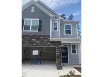 New construction home features a gray facade with stone accents and an attached two-car garage at 1524 Chirping Bird Ct, Cary, NC 27519