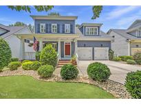 Charming two-story home featuring a landscaped front yard and a welcoming red front door at 204 Edgepine Dr, Holly Springs, NC 27540