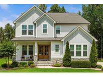 Charming two-story home featuring a welcoming front porch, stone accents, and well-manicured landscaping at 2716 Willow Rock Ln, Apex, NC 27523