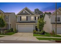 Charming two-story home featuring gray siding, black shutters, and a well-manicured lawn and landscaping at 3224 Star Gazing Ln, Durham, NC 27703
