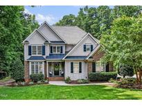 Charming two-story home featuring manicured lawn, brick and siding, and mature trees on a sunny day at 3748 Westbury Lake Dr, Raleigh, NC 27603