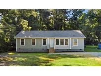 Charming single-story home with light green siding, gray roof, and inviting front entrance surrounded by lush trees at 41 Andrea Ct, Sanford, NC 27332