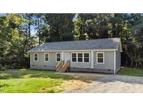 Charming single-story home featuring light gray siding, a well-manicured lawn, and a welcoming front porch at 41 Andrea Ct, Sanford, NC 27332