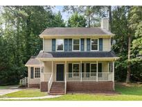 Charming two-story home featuring blue shutters and a cozy front porch, creating a welcoming curb appeal at 5429 Fortunes Ridge Dr, Durham, NC 27713