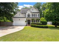 Charming two-story home features a manicured lawn, attached garage, and welcoming front porch at 5833 Dahlberg Dr, Raleigh, NC 27603