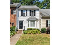 Charming townhouse with black shutters, a bay window, and manicured front lawn at 6051 Epping Forest Dr, Raleigh, NC 27613