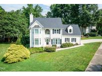 Charming two-story white home with black shutters, lush green lawn, and mature trees at 6205 Remington Lake Dr, Raleigh, NC 27616