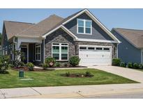 Charming single-Gathering home with stone accents, attached two-car garage, manicured lawn, and fresh landscaping at 67 Blue Spruce Cir, Clayton, NC 27527