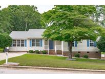 Charming ranch-style home with a well-manicured lawn and blue shutters at 700 Mossburn Ct, Fuquay Varina, NC 27526