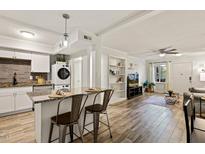 Open-concept living room with modern kitchen, sleek island seating, and an airy, inviting atmosphere at 7002 Longstreet Dr # C, Raleigh, NC 27615