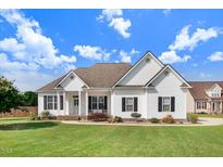 Charming one-story home featuring white siding, a manicured lawn, and a classic architectural design at 8101 Claybrooke Ct, Willow Springs, NC 27592