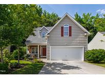 Charming home featuring a two-car garage, stone porch accents, and well-maintained landscaping at 8205 Rolling Glenn Dr, Raleigh, NC 27616