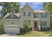 Charming two-story home with blue shutters, a red front door, and a well-manicured lawn at 860 Cokesbury Rd, Fuquay Varina, NC 27526