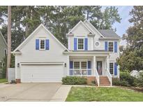 Charming two-story home with a well-manicured lawn, two-car garage, and inviting front porch at 102 Duxbury Dr, Cary, NC 27513