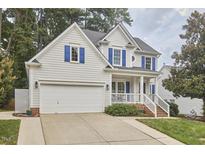 Charming two-story home featuring a two-car garage, blue shutters, and manicured landscaping at 102 Duxbury Dr, Cary, NC 27513