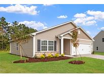 Charming home featuring stone accents, shutters, a two-car garage, and manicured lawn at 107 Flue Ct, Oxford, NC 27565