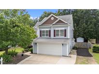 Charming two-story home with a two car garage, a well-maintained lawn and mature trees at 1144 Dexter Ridge Dr, Holly Springs, NC 27540