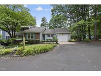 Charming single-story home with mature trees, a well-manicured lawn, and a private driveway at 1500 Laureldale Dr, Raleigh, NC 27609