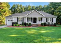 Charming single-story home with a manicured lawn, tidy landscaping, and an attached two-car garage at 1515 Bradsher Dr, Stem, NC 27581