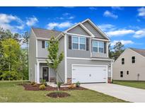 Charming two-story home boasts a well-manicured lawn and a two-car garage at 205 Benton Dr, Oxford, NC 27565