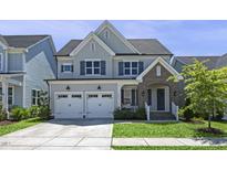 Charming two-story home with a well-manicured lawn, attached two-car garage, and inviting front porch at 217 Tumbling River Dr, Wendell, NC 27591