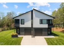 Contemporary duplex with a well-manicured lawn and modern design elements including individual 1-car garages at 2201 Millbank Village Ct # 101, Raleigh, NC 27610