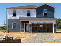 New two-story home shows blue siding, windows, and a two-car garage under construction at 311 Thistle Patch Pl, Angier, NC 27501