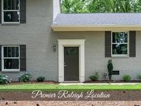 Charming gray brick home with a dark front door and neatly manicured landscaping at 4301 Azalea Dr, Raleigh, NC 27612