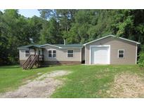 Charming single-story home with a metal roof, front porch, and an attached one-car garage on a sunny day at 440 Montgomery Rd, Franklinton, NC 27525