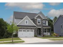 Charming two-story home featuring stone accents, a two-car garage, and a well-maintained lawn at 4416 Walker Hallow St, Raleigh, NC 27616