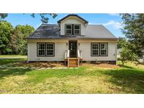 Charming home featuring white siding, a metal roof, black trim, and a welcoming front entrance at 505 Hawfields Rd, Mebane, NC 27302