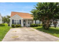 Charming home featuring manicured lawn, mature tree, and inviting front porch, perfect for relaxing outdoors at 5104 Parkerwood Dr, Knightdale, NC 27545