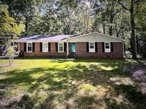 Charming one-story brick home with a well-maintained lawn and beautiful, mature trees at 512 Crestview Dr, Durham, NC 27712