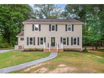 Charming two-story home featuring classic curb appeal with symmetrical windows and a well-maintained front yard at 5900 Holly Dr, Raleigh, NC 27616
