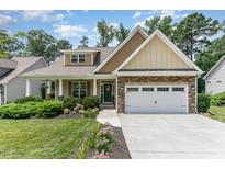 Charming home with stone accents, a two-car garage, and a beautifully landscaped front yard at 6 Tulip Tree Ct, Durham, NC 27712