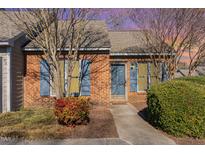 Charming brick townhome with well-maintained landscaping and blue shutters at 61 Fashion Pl, Durham, NC 27705