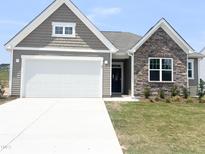 Charming home featuring stone and neutral siding with a bright white garage door at 67 Furley St., Homesite 117, Sanford, NC 27330