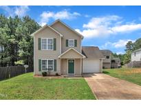 Charming two-story home with a well-manicured lawn, attached garage, and inviting curb appeal at 71 Herndon Ct, Clayton, NC 27520