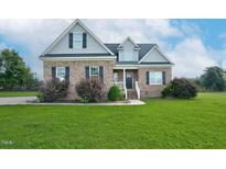 Inviting brick home featuring a manicured lawn and tasteful landscaping at 7107 Elkhorn Rd, Rocky Mount, NC 27803