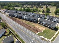 New townhome community featuring modern exteriors, landscaping, and a nearby golf course for added recreational opportunities at 749 Parc Townes Dr # 33, Wendell, NC 27591