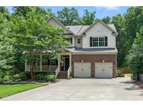 Charming two-story home featuring brick facade, a two-car garage, covered porch, and well-maintained landscaping at 776 Legend Oaks Dr, Chapel Hill, NC 27517