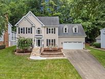 Charming two-story home with well-manicured lawn, attached two car garage, and a stone walkway leading to the front door at 7808 Sandy Bottom Way, Raleigh, NC 27613