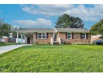 Charming brick home featuring a well-manicured lawn and a convenient carport at 801 Lincoln Dr, Rocky Mount, NC 27801