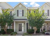 Inviting townhouse with light green siding, well-manicured landscaping, and a charming front entrance at 8326 Glenwood Springs Ct, Raleigh, NC 27616